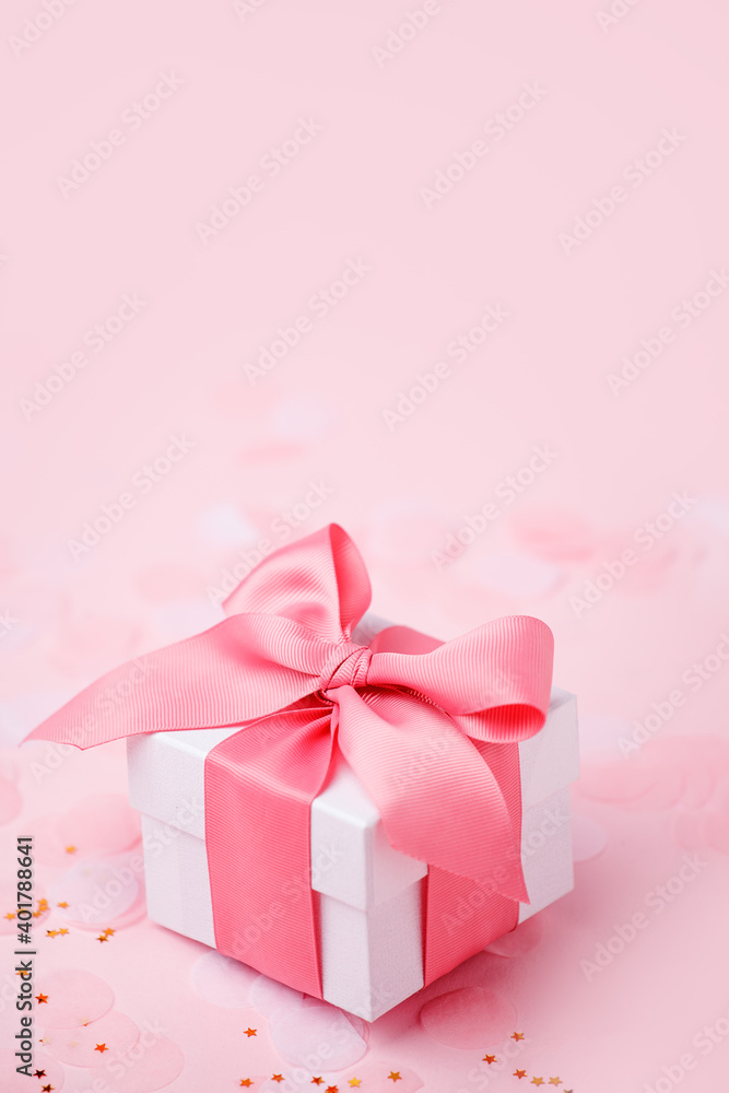 Holiday pink background with gift, white satin bow, ribbon. Valentine's Day, Happy Women's Day, Mother's Day, Birthday, Wedding, Christmas. space for text