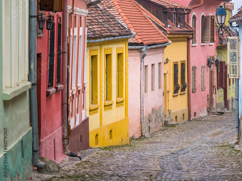 Colorful scene with cobblestone streets and old buildings of Sighisoara Medieval Fortress, in Romania.