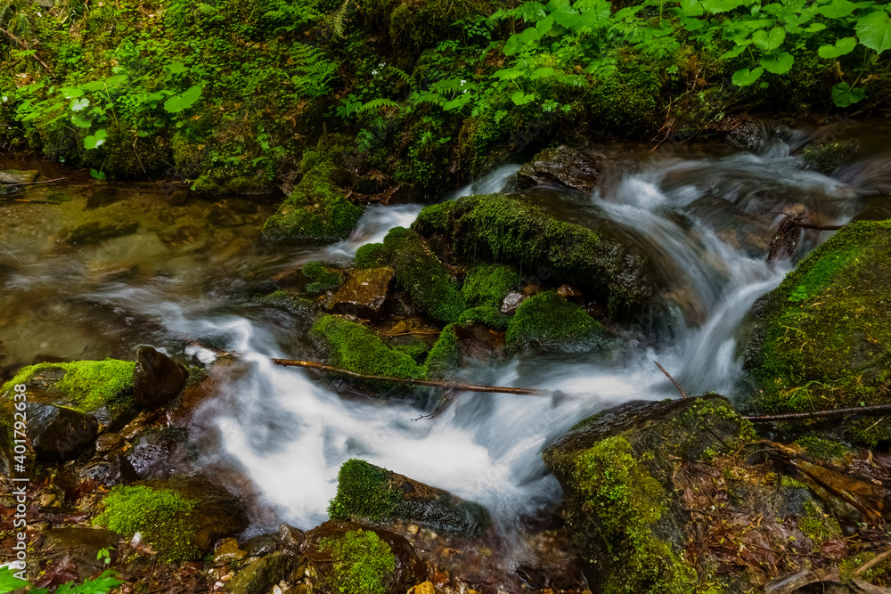 beautiful flowing water between rocks with green moss beautiful flowing water between rocks with green moss