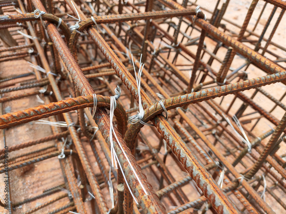 SEREMBAN, MALAYSIA -MARCH 29, 2020: Construction workers fabricating steel reinforcement bar at the construction site. They tied it together using the tiny wires before cover it up using formworks. SEREMBAN, MALAYSIA -MARCH 29, 2020: Construction workers fabricating steel reinforcement bar at the construction site. They tied it together using the tiny wires before cover it up using formworks.