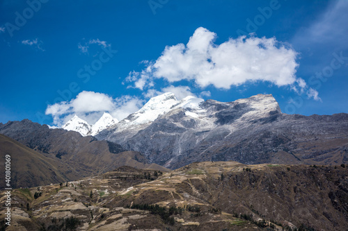 Fototapeta Naklejka Na Ścianę i Meble -  campo cultivado y cordillera de los majestuosos Andes imponentes y nevados con cielos azul intenso con nubes en Perú