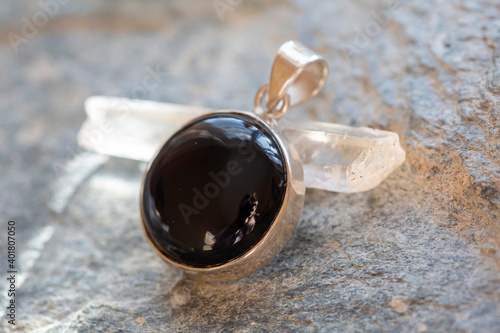 Φωτογραφία Sterling silver pendant with mineral onyx gemstone on rocky background