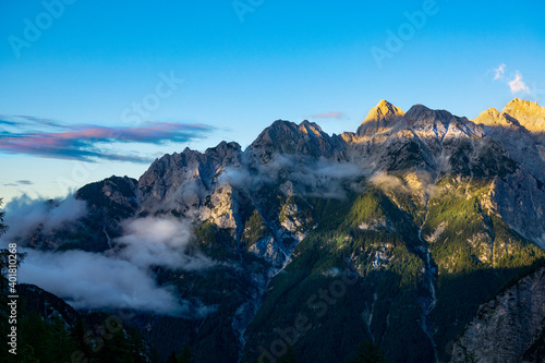 AERIAL: Spectacular view of the gorgeous Julian Alps at golden spring sunrise.