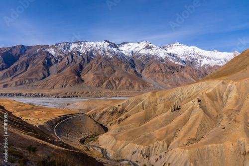 Serene Landscape of Spiti river valley and snow capped mountains during sunrise near Kaza town in Lahaul and Spiti district of Himachal Pradesh, India.