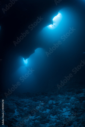 Light seeps into a dark, underwater cavern in the Republic of Palau. This famous dive site is known as "Blue Holes." Palau is known for its extraordinary scuba diving, snorkeling, and kayaking.