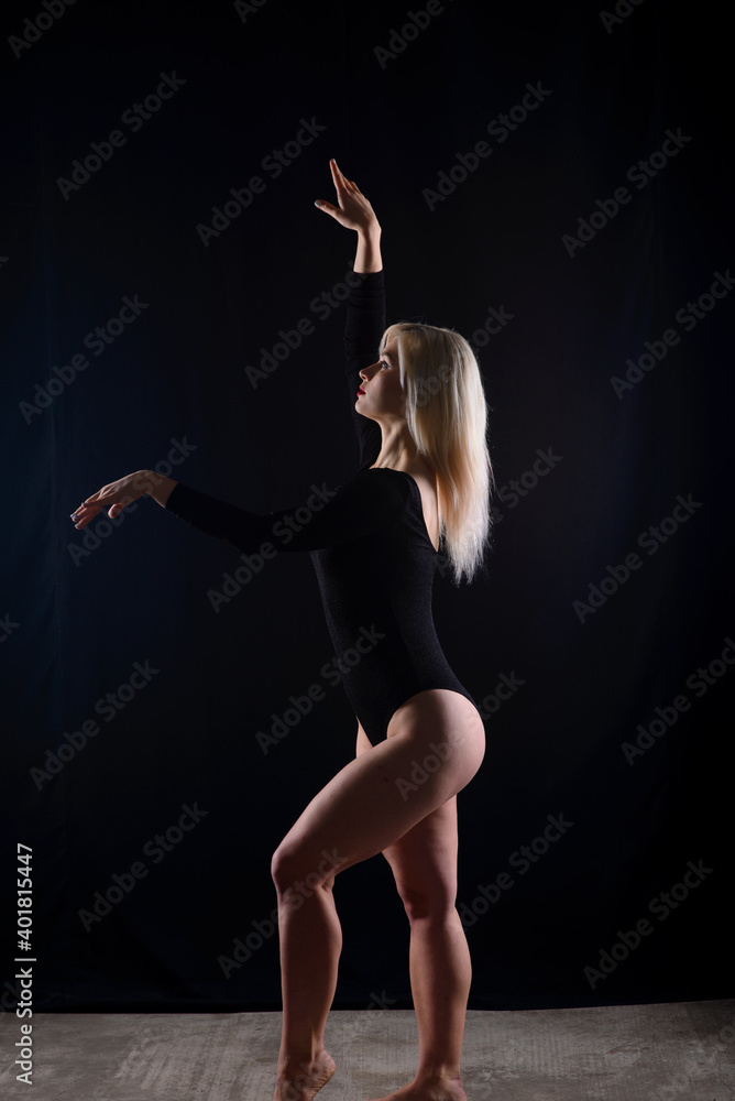 Young blonde plump woman with bright makeup in black bodysuit at dark background