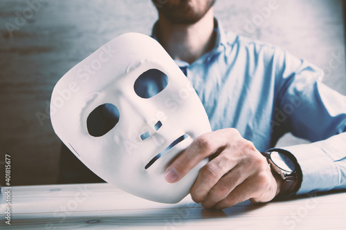 Foto Businessman holding white mask in his hand