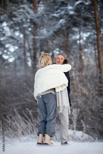 adult man and woman hugging on the street in winter