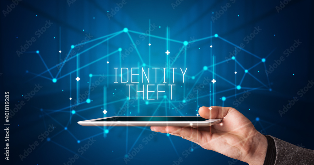 Young business person working on tablet and shows the digital sign: IDENTITY THEFT Young business person working on tablet and shows the digital sign: IDENTITY THEFT