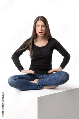 Serious and rough woman sitting in the lotus position. Isolated image on the white studio background.
