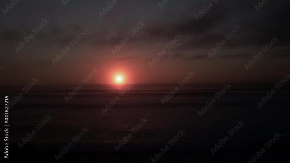 Mesmerizing golden amber sunset reflecting off a vast black seascape, aerial track Mesmerizing golden amber sunset reflecting off a vast black seascape, aerial track
