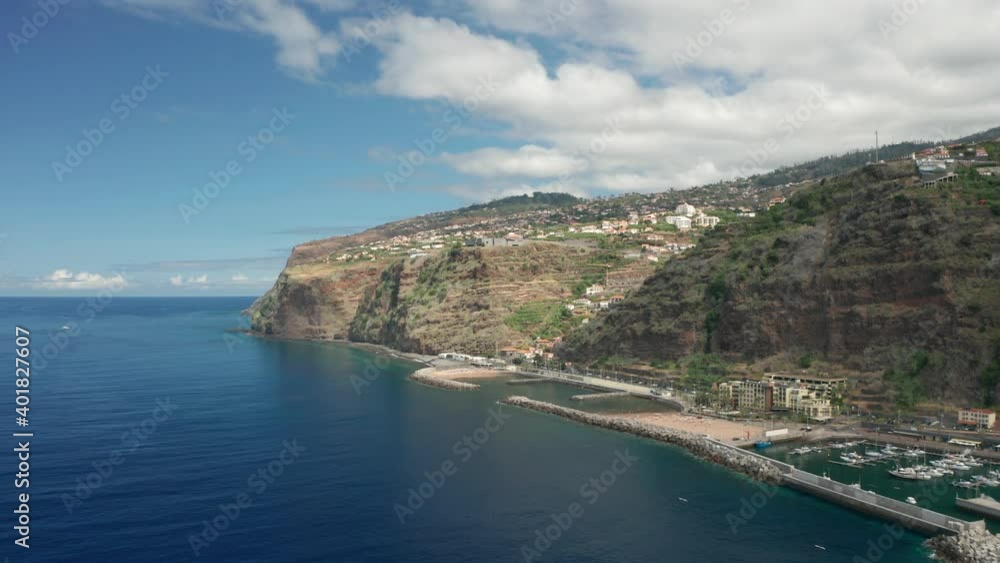 Sunny day at Calheta shore with cliffs on Madeira Island with man made beach Sunny day at Calheta shore with cliffs on Madeira Island with man made beach