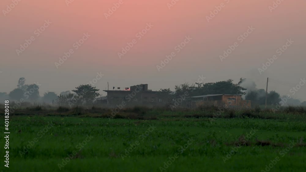 Zoomout timelapse of sun setting behind the farm house in the countryside Zoomout timelapse of sun setting behind the farm house in the countryside