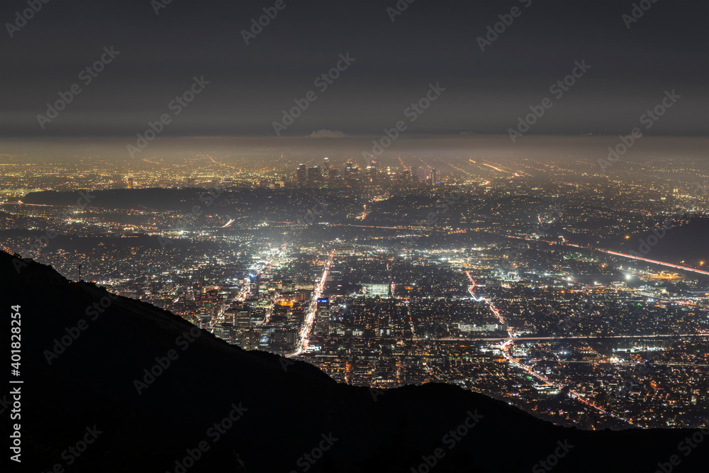 Hazy night hilltop view of Glendale California with downtown Los Angeles towers in background..