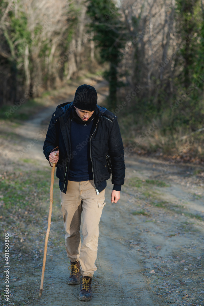 Guy doing trekking in a natural landscape during winter season practicing outdoors activity holding walking stick pole. Guy doing trekking in a natural landscape during winter season practicing outdoors activity holding walking stick pole.