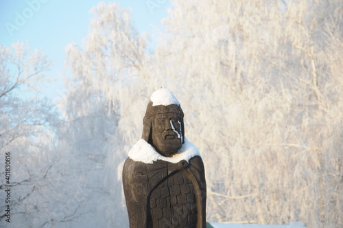 Russian pagan god-warrior. Sculpture in winter frosty forest photo