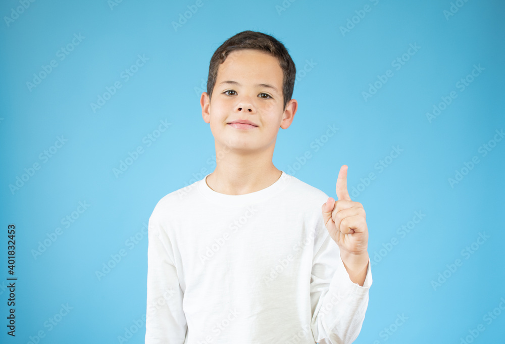 Portrait of cheerful boy with good idea - isolated over blue background. 10 year old kid pointing finger up. Child points by finger upward. Cheerful boy shows something Portrait of cheerful boy with good idea - isolated over blue background. 10 year old kid pointing finger up. Child points by finger upward. Cheerful boy shows something