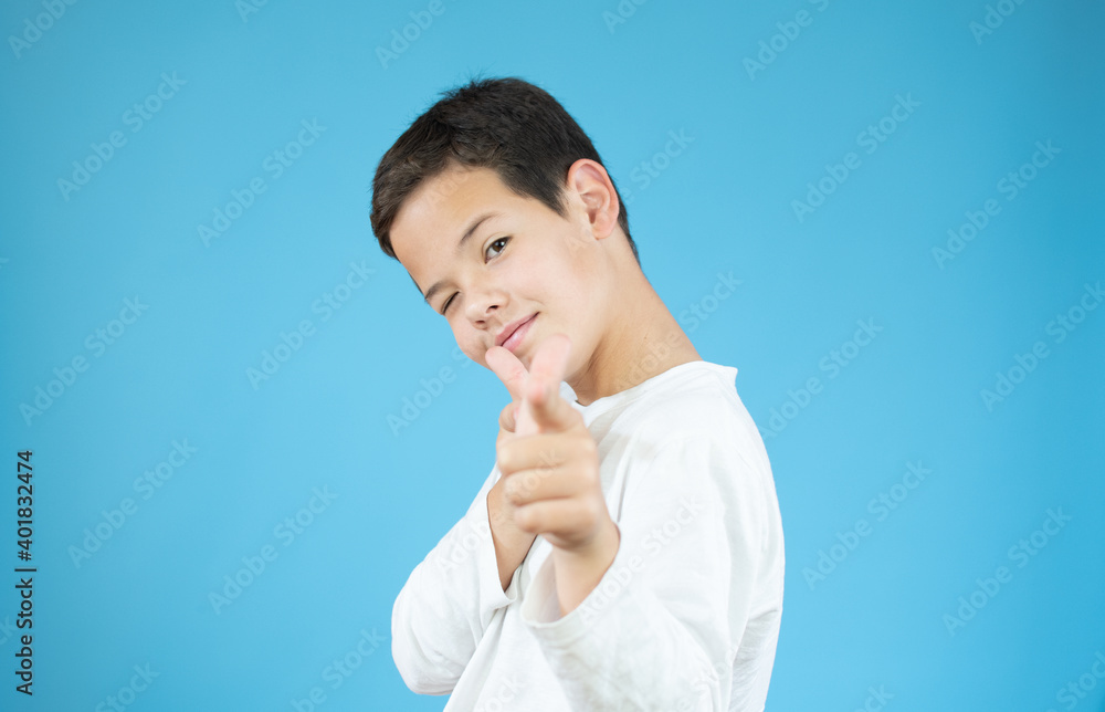 Portrait of a beautiful caucasian young boy smiling making a happy gesture over blue background Portrait of a beautiful caucasian young boy smiling making a happy gesture over blue background