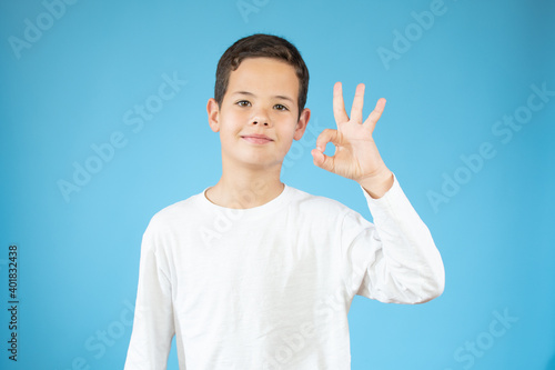 Handsome toddler child with brown eyes raising finger, is the number three