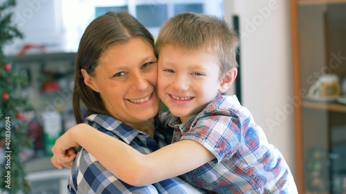 Mother and son are kissing and hugging each other. The relationship between mother and son