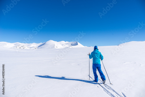 Man on cross country skis in the mountains near Hovringen in Rondane National Park, Norway photo