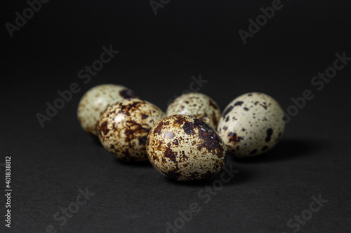 Quail eggs on a black background. Healthy food. Several quail eggs lie next to each other