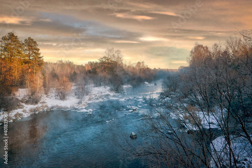 Winter landscape the river in the forest at sunset. Winter sunset rural river landscape. © Anatoliy