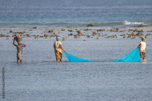 African woman using locally made net for fishing during low tide, Indian Ocean, Mozambique