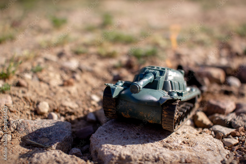 Toy plastic tank driving on the road and smoking