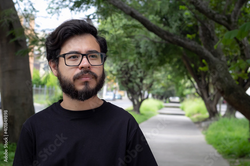 portrait of a latino man with beard and glasses