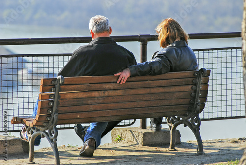 An older couple sits on a bench and enjoys the view