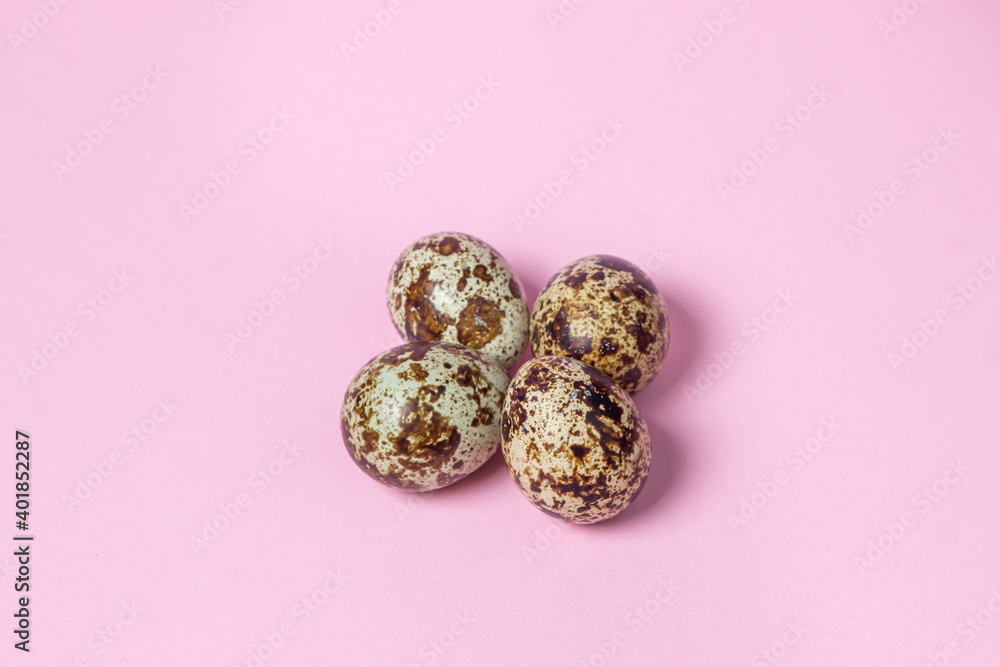 Quail eggs on a pink background. Healthy food. Several quail eggs lie next to each other