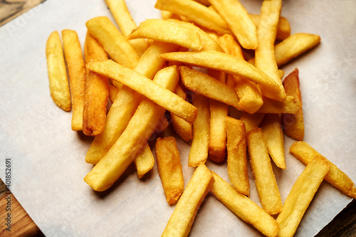 French fries on white paper background, close-up