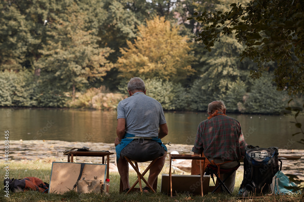 Two men is drawing swans in an oniric berliner lake. Two men is drawing swans in an oniric berliner lake.