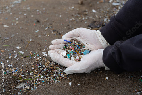 Fotografi A shot hands with gloves holding a handful of microplastic