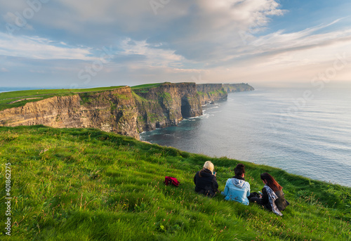 Girls sitting near the edge of the cliffs of Moher 