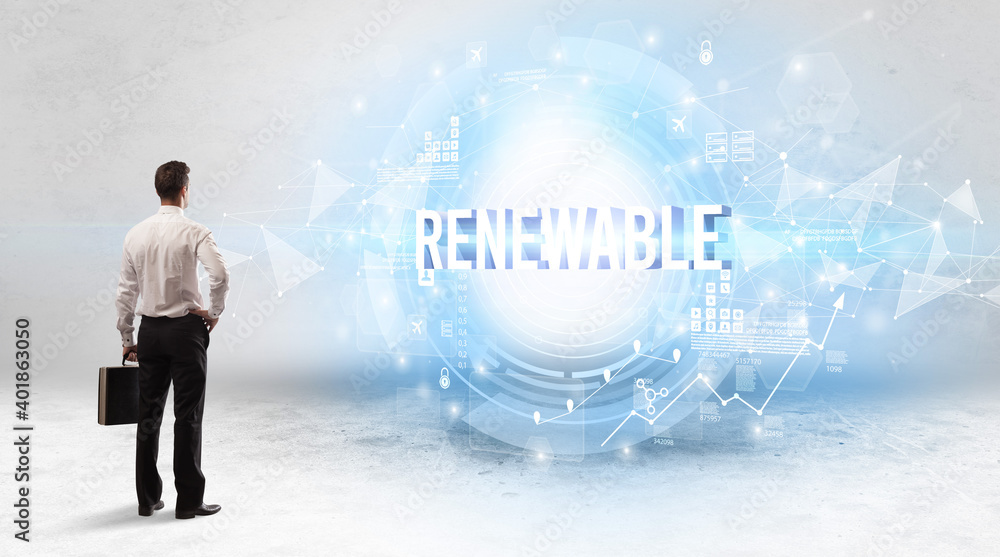 Rear view of a businessman standing in front of RENEWABLE inscription, modern technology concept Rear view of a businessman standing in front of RENEWABLE inscription, modern technology concept