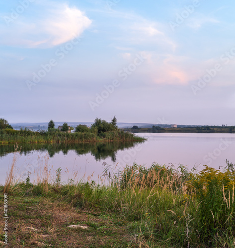 Evening dusk on summer valley lake. Natural seasonal, weather, countryside beauty concept and background scene.
