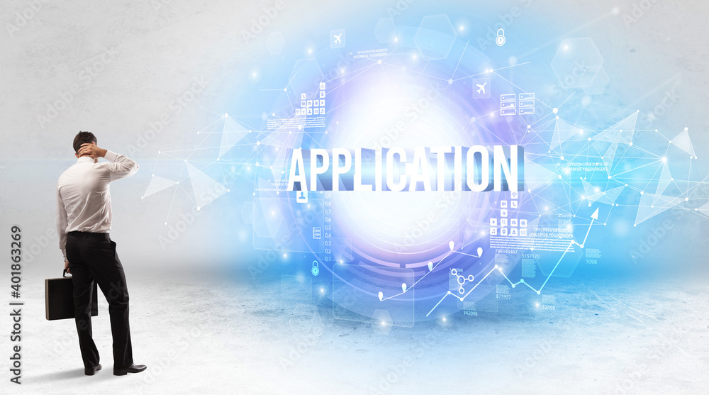 Rear view of a businessman standing in front of APPLICATION inscription, modern technology concept