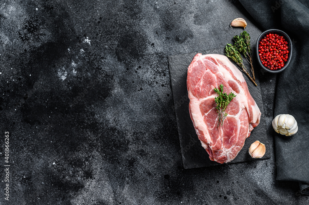 Raw pork neck meat. Chop steak. Black background. Top view. Copy space