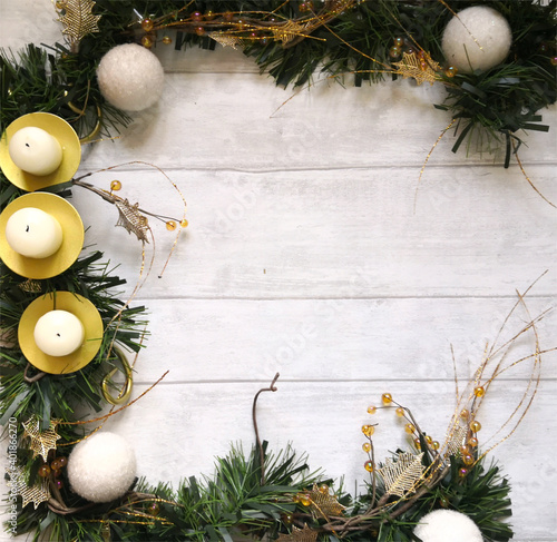 Winter composition with green garland, candles and white baubles on wooden surface with space for text. Flat lay, top view, from above, copy space. Winter and Christmas background.