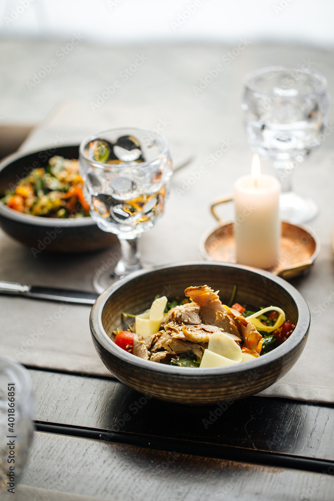 Table served with a bowl with beef salad with vegetables and cheese Table served with a bowl with beef salad with vegetables and cheese