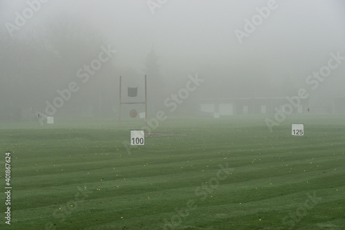 Golf driving range in autumn morning fog