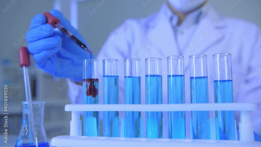 Research concept of 4k resolution. A scientist dripping liquid into a test tube. Research concept of 4k resolution. A scientist dripping liquid into a test tube.