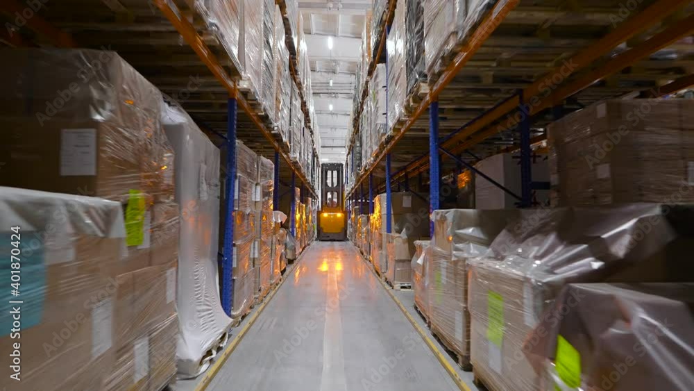 Equipment components are stored on racks. The yellow forklift drives through the rows. Equipment components are stored on racks. The yellow forklift drives through the rows.