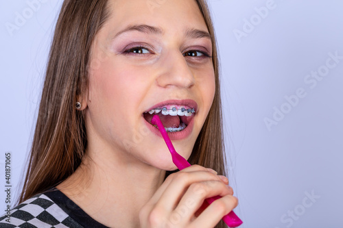 Dentist and orthodontist concept. Girl with braces cleaning teeth using brushes