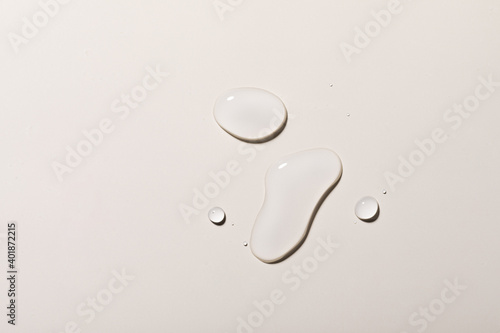 A top view closeup of multiple water drops on a light purple background