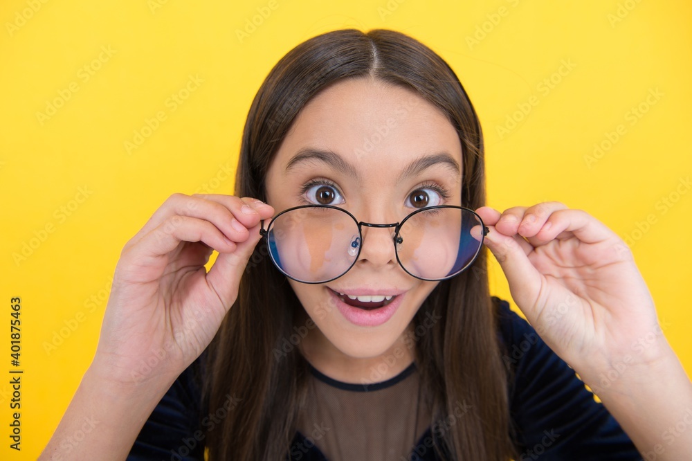 amazed smart girl child with long hair and eyeglasses on yellow background, surprise amazed smart girl child with long hair and eyeglasses on yellow background, surprise