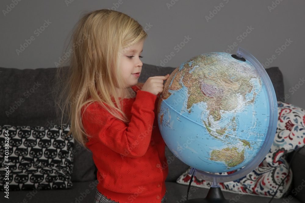 Portrait of adorable 3 years old girl playing with a globe. Portrait of adorable 3 years old girl playing with a globe.
