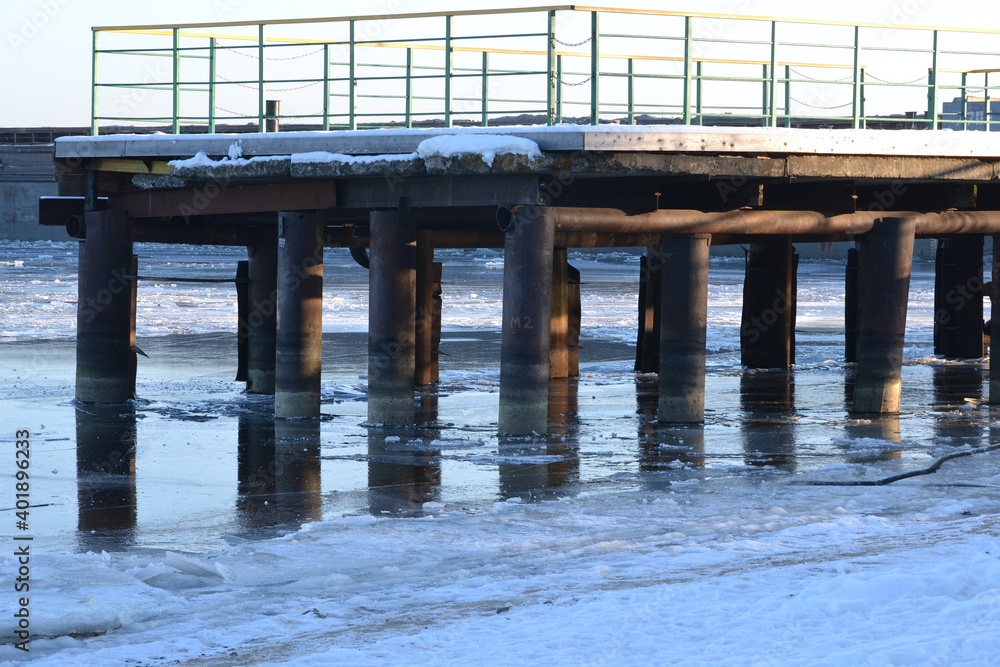 pier on a frozen sea covered with ice in winter